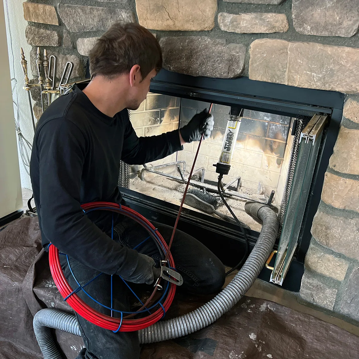 Illustrative chimney flue maintenance performed from the fireplace opening